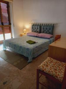 een slaapkamer met een bed met roze kussens bij Casa Nancy in Palizzi Marina