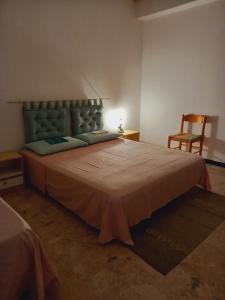 een slaapkamer met een groot bed en een stoel bij Casa Nancy in Palizzi Marina