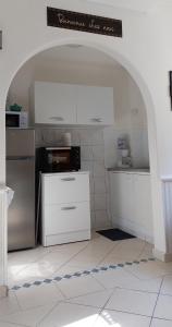 uma cozinha com armários brancos e um aparelho preto e branco em LE CISE EAU À bois em Le Bois de Cise