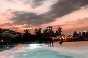 ein großer Pool mit einem Sonnenuntergang im Hintergrund in der Unterkunft Apartmant with Pool 8 in Kaštela