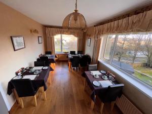 a dining room with tables and chairs and a window at The Sheiling B&B - NC 500 in Melvich