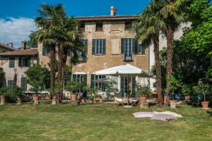 a building with palm trees in front of it at Bed and Breakfast Locanda Lugagnano in Cassinetta di Lugagnano