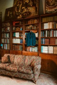 a living room with a couch in front of book shelves at Bed and Breakfast Locanda Lugagnano in Cassinetta di Lugagnano