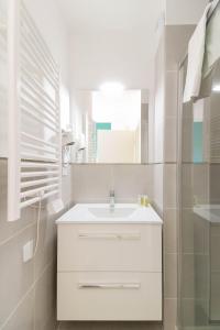 a white bathroom with a sink and a mirror at SELECT'SO HOME - Résidence Le Poséidon - Mazet en Duplex - Prestations de qualité & Services Hôteliers - POS-D in Bormes-les-Mimosas
