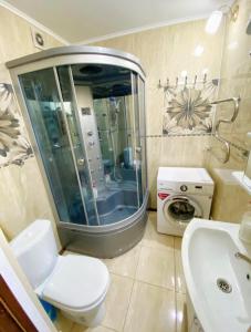 a bathroom with a toilet and a sink and a shower at Apartments Ahmetova 4 21 in Almaty