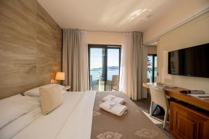 una camera d'albergo con letto, scrivania e TV di Hotel Aleksandar Rafailovići a Budua