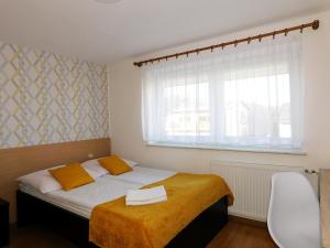 sypialnia z łóżkiem z żółtym kocem i oknem w obiekcie Family Homes - Dom Wakacyjny EDA we Władysławowie
