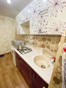 a kitchen with a sink and a stove at Apartments Ahmetova 4 21 in Almaty