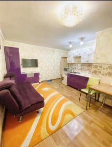 sala de estar con sofá, mesa y cocina en Apartments Ahmetova 4 21, en Almaty