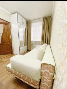 um quarto com uma cama e uma janela em Apartments Ahmetova 4 21 em Almaty