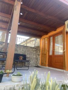 a patio with a wooden door and a bench at Apartman Sara in Grižane