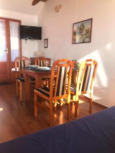 a dining room with a table and four chairs at Apartman Sara in Grižane