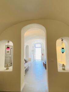 a room with a hallway with a couch and a table at Ikia Kriton in Imerovigli +64 photos