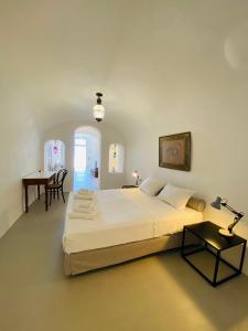 a bedroom with a large bed and a table at Ikia Kriton in Imerovigli
