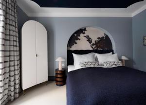 a bedroom with a large bed with blue walls at numa I Maximilian in Salzburg