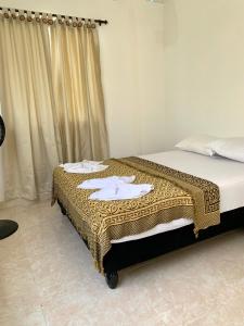 um quarto com uma cama com um cobertor castanho e branco em Casa Santiago Mayor em Cali