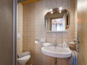 łazienka z umywalką, toaletą i lustrem w obiekcie Appartement Traumblick w mieście Fügen