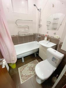 y baño con aseo, bañera y lavamanos. en Apartments Ahmetova 6 32, en Almaty