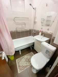 a bathroom with a toilet and a tub and a sink at Apartments Ahmetova 6 32 in Almaty