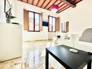 a living room with a table and a couch at Il Barbero Apartment in Siena