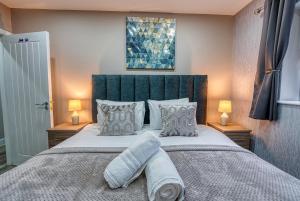 a bedroom with a large bed with pillows at Stylish House - B'ham Airport and NEC, JLR Solihull, Business & Leisure Stays - Aspen House in Solihull