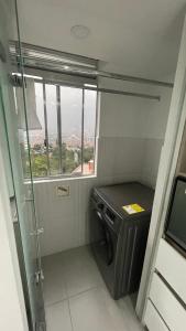 a bathroom with a washing machine and a window at gray house in Medellín