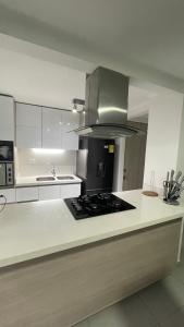 a kitchen with white cabinets and a stove top oven at gray house in Medellín