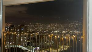 a view of a city at night from a window at gray house in Medellín
