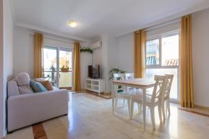 a living room with a table and a couch at Luminoso apartamento de dos habitaciones con terraza y parking en el centro in Málaga