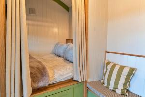 une chambre avec un lit à l'intérieur d'une maison dans l'établissement Finest Retreats - The Shepherd's Hut at Northcombe Farm, à Beaworthy