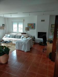 een woonkamer met een bed en een televisie bij chalet, kuki in Ribas