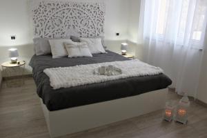 - une chambre blanche avec un grand lit et des oreillers blancs dans l'établissement Stella del mare - casa incantevole con piscina e parcheggio privato, à Cervo
