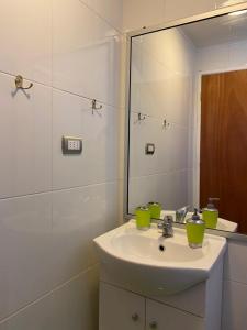 een badkamer met een wastafel en een spiegel bij Cabaña Pichilemu in Pichilemu
