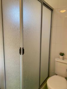 een badkamer met een toilet en een glazen douchedeur bij Cabaña Pichilemu in Pichilemu