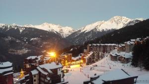 - Vistas a una estación de esquí con montañas cubiertas de nieve en Superbe appartement en résidence skis aux pieds en Courchevel