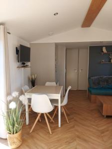 een woonkamer met een witte tafel en stoelen bij Luxe Chalet Lauwersoog in Lauwersoog