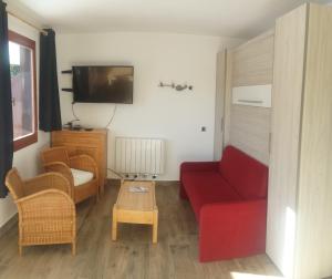 ein Wohnzimmer mit einem roten Sofa und einem TV in der Unterkunft Superbe appartement en résidence skis aux pieds in Courchevel