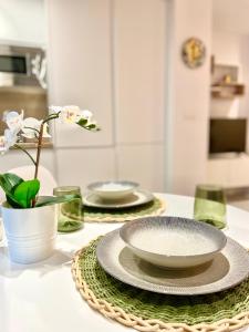 a table with two plates and a bowl on it at Cozy apartamento en distrito centro de Málaga in Málaga