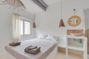 Un dormitorio blanco con una cama con toallas. en LaFrenchCasa Belsunce, en Marsella
