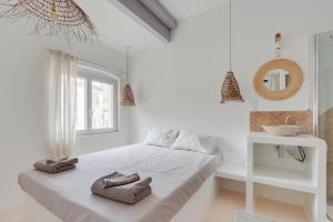 a white bedroom with a bed with towels on it at #LaFrenchCasa Belsunce in Marseille