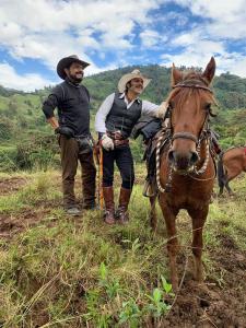 BaezaにあるPosada Campo Libreの野馬の横に立つ二人