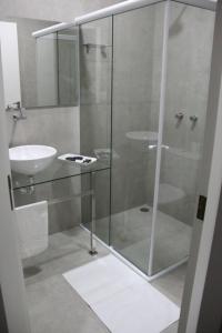 a bathroom with a glass shower and a sink at Caculé Palace Hotel in Caculé