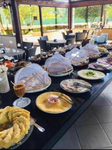 uma mesa longa com pratos de comida em Flats no Nannai Residence - Muro Alto - Porto de Galinhas - Brasil em Porto de Galinhas