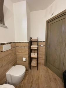 a bathroom with a white toilet and a wooden floor at Casa Manzoni in La Maddalena