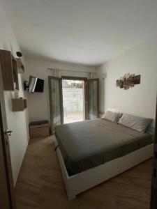 a bedroom with a large bed and a window at Casa Manzoni in La Maddalena
