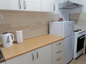 uma cozinha com armários brancos e um frigorífico branco em Apartman Radulović em Kladovo