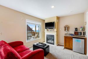 uma sala de estar com um sofá vermelho e uma lareira em Captain's Quarters - Cabana em Depoe Bay