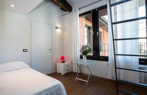 モンツァにあるLT - Room's Bed & Livingのベッドとテーブルと窓のある寝室