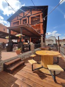 un patio con mesas y bancos de madera y un edificio en Hostal Restaurante Serrania, en Tragacete
