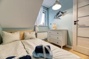 a bedroom with a bed with a blue wall at Apartamenty Cichowierzbowo in Ściegny